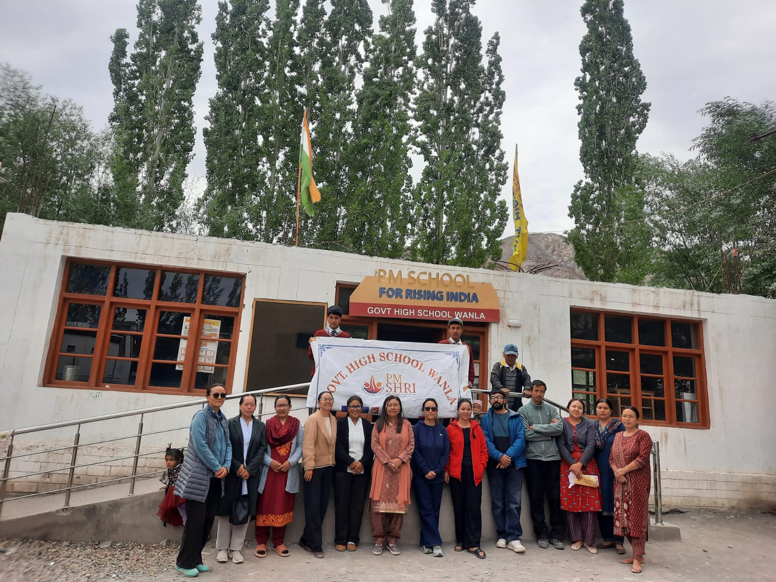 Staff of Government High School Wanla standing in front of the PM SHRI school building